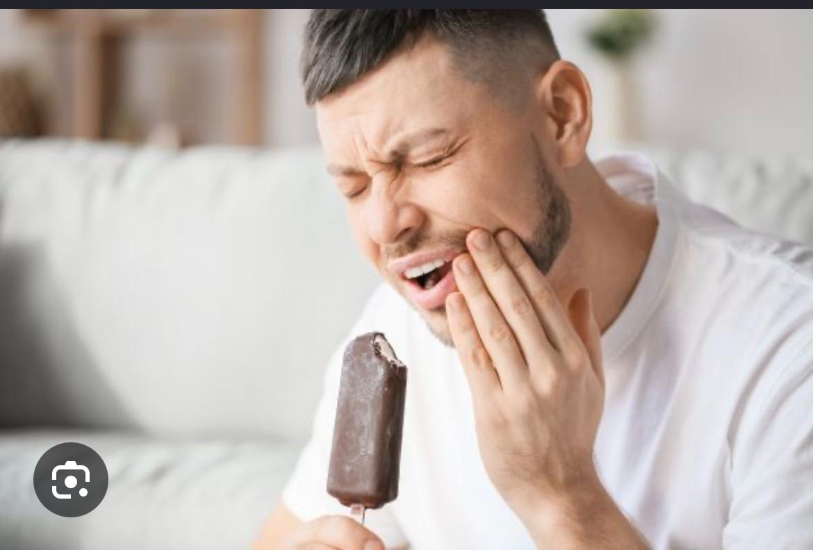 Persona que siente una molestia dental al comer un helado